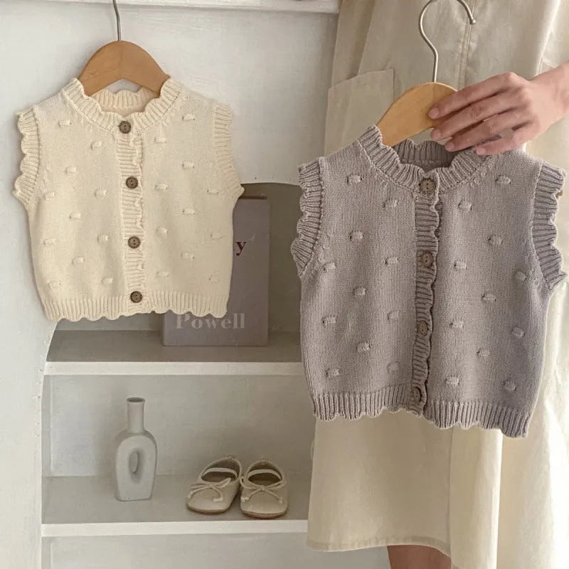 Children's knitted polka dot vest in apricot with single-breasted closure, featuring a sleeveless design for spring and autumn