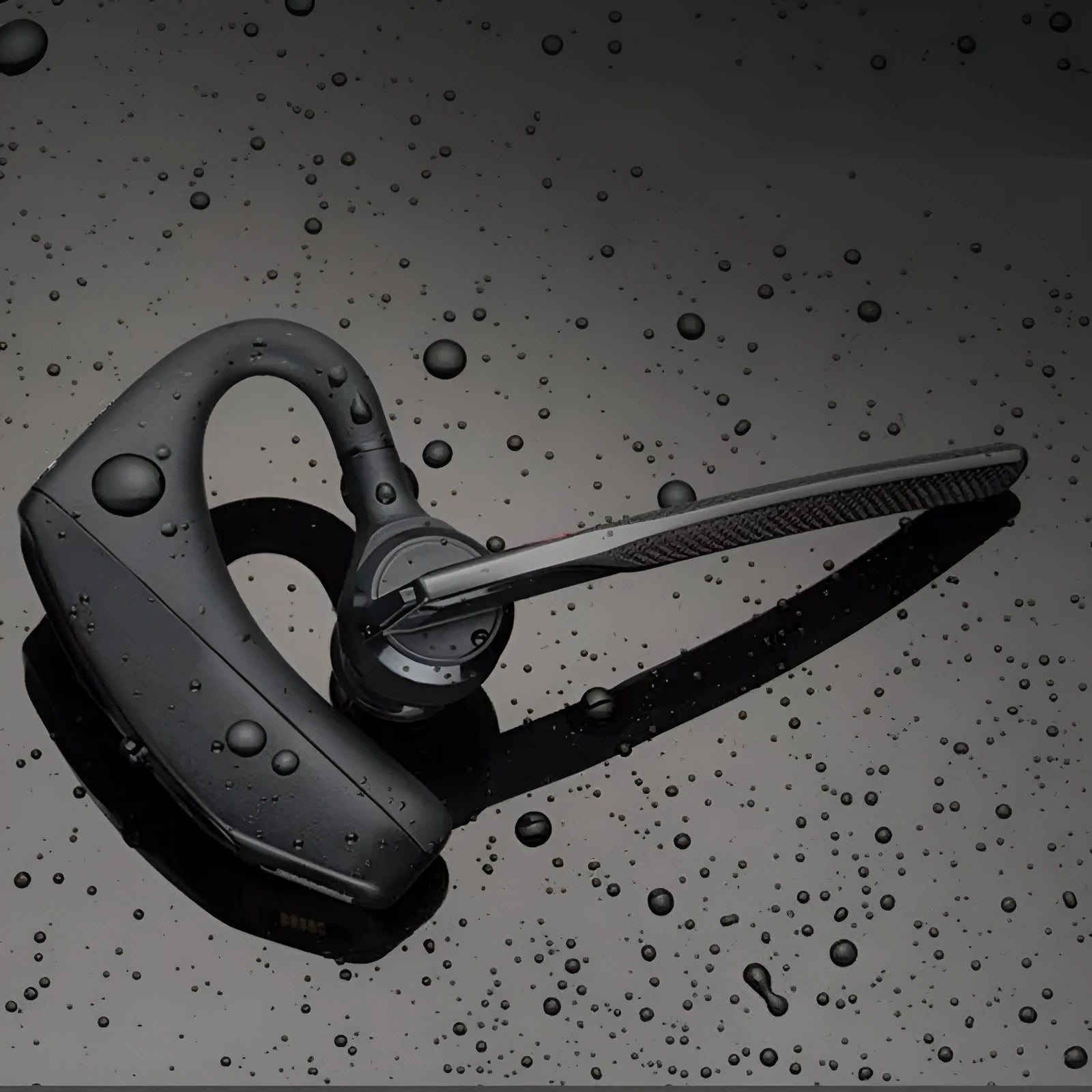 Black plastic Bluetooth sports headphones with a large battery, shown with a USB cable.