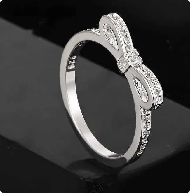 Silver-coloured fashion ring with a bow design adorned with clear zircon crystal stones.