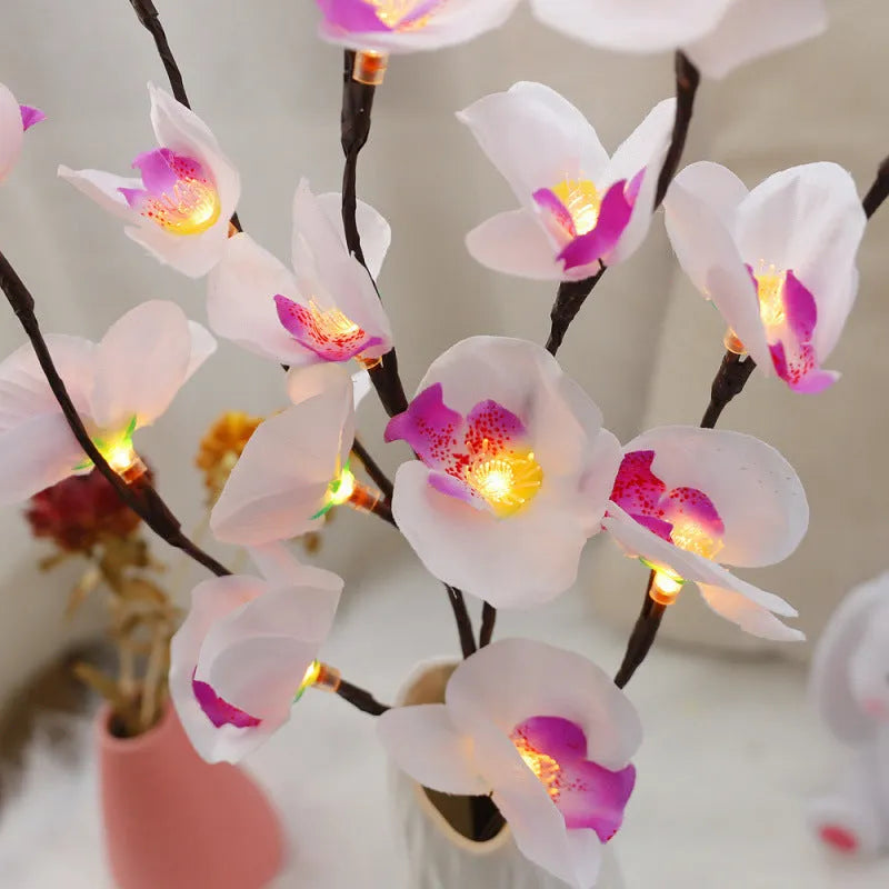 A 65cm long pink LED phalaenopsis branch decorative light on a dark background.