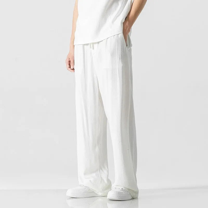 Man wearing beige cropped straight-leg linen trousers with a drawstring waist.