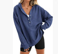 Woman wearing a loose, peacock green raglan sleeve pullover sweater.