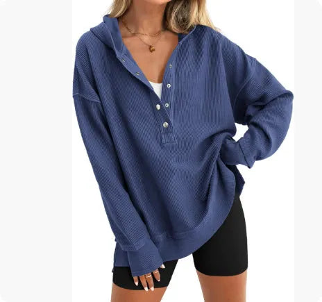 Woman wearing a loose, peacock green raglan sleeve pullover sweater.