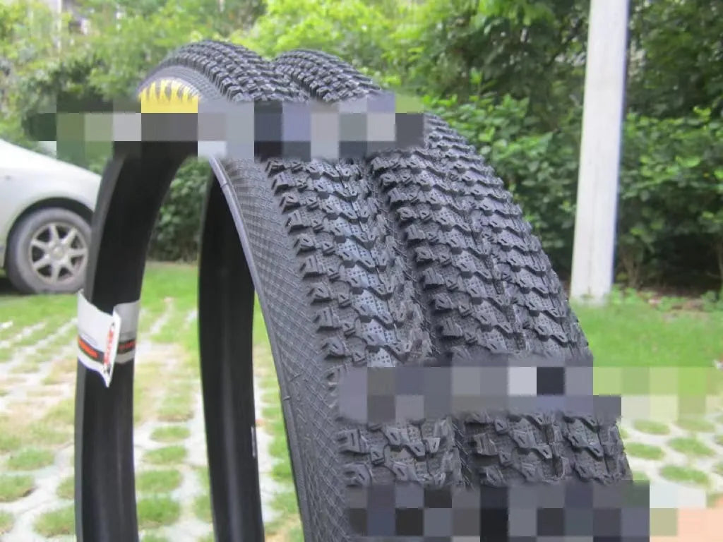 Ultralight mountain bike tyre with reinforced black sidewall shown next to size and weight specifications.