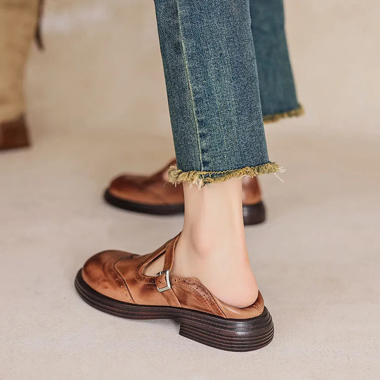 Women's black British style leather flat shoe with round toe and slip-on design on a neutral background.