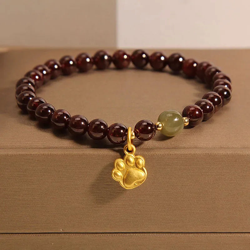 Women's original design Cat's Paw Garnet crystal bracelet on a plain background.