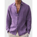 Man wearing a loose fit, short sleeve, striped cardigan shirt in a casual setting.