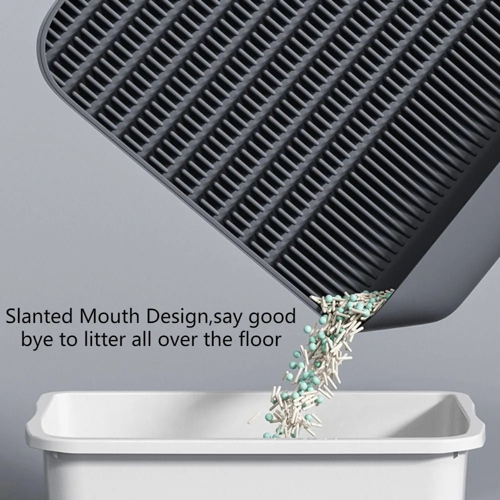 Large black cat litter pedal with slanted mouth and textured grooves beside a litter tray