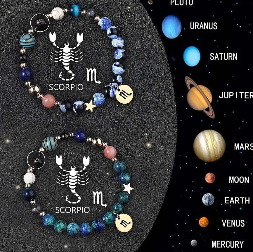 Set of two natural stone beaded bracelets showing zodiac symbols on a table.