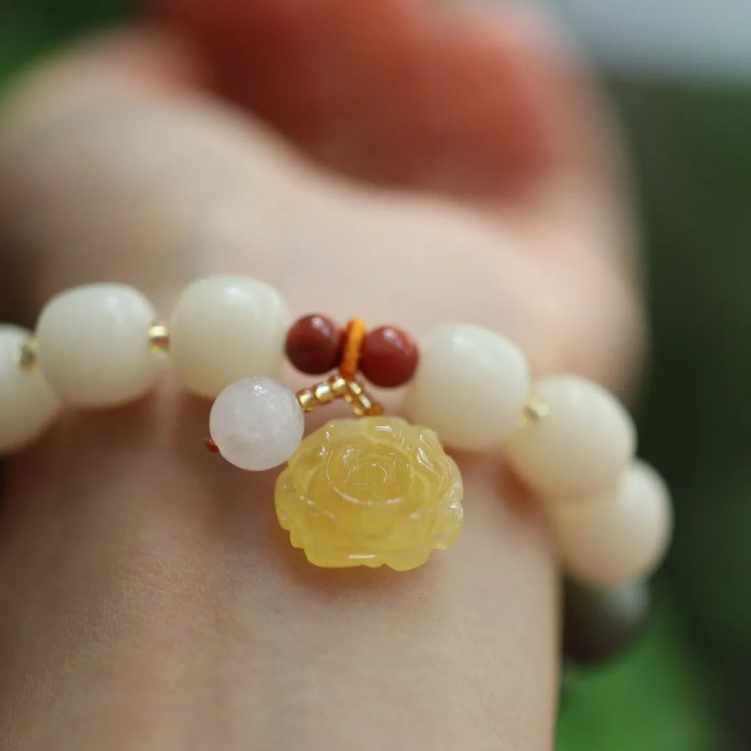 Close-up of a 10mm floral bracelet made from woven Bodhi root with gradient white jade and a natural beeswax lotus bead.
