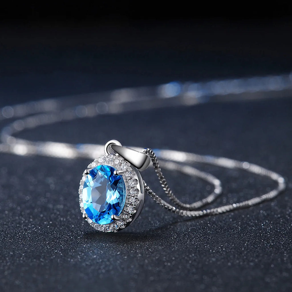 925 sterling silver four-piece jewellery set with blue topaz gems showing geometric-designed earrings, ring, pendant, and necklace