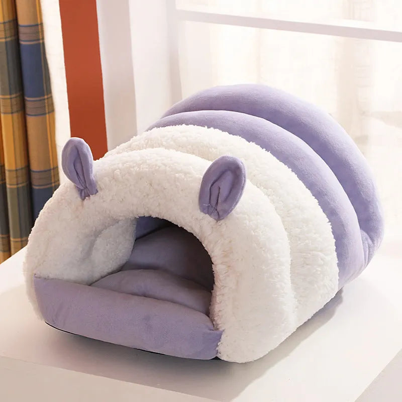 Blue enclosed cat nest with a round entrance, shown on a wooden floor.