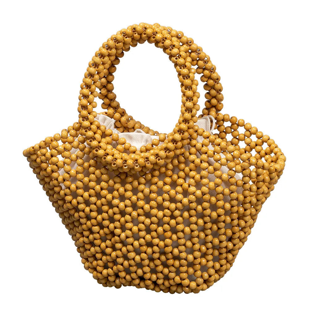 Hand-woven dumpling-shaped beach bag with wooden beads in milky white.