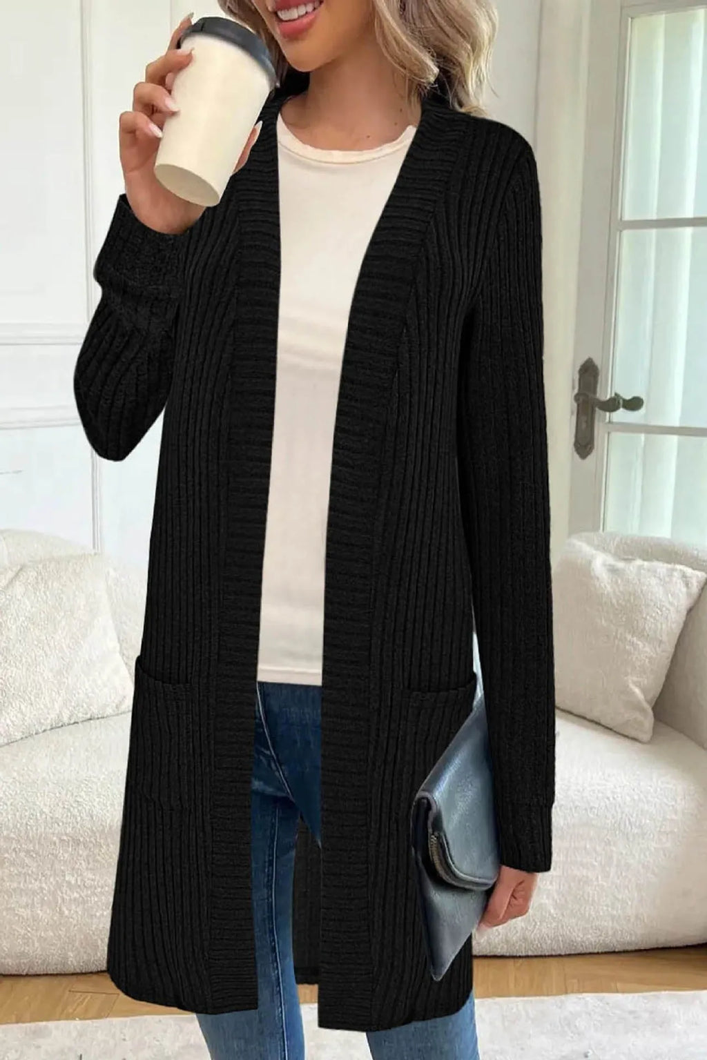 A woman wearing a loose-fit long sleeve knitted cardigan jacket with pockets, available in black, grey, or wine red.