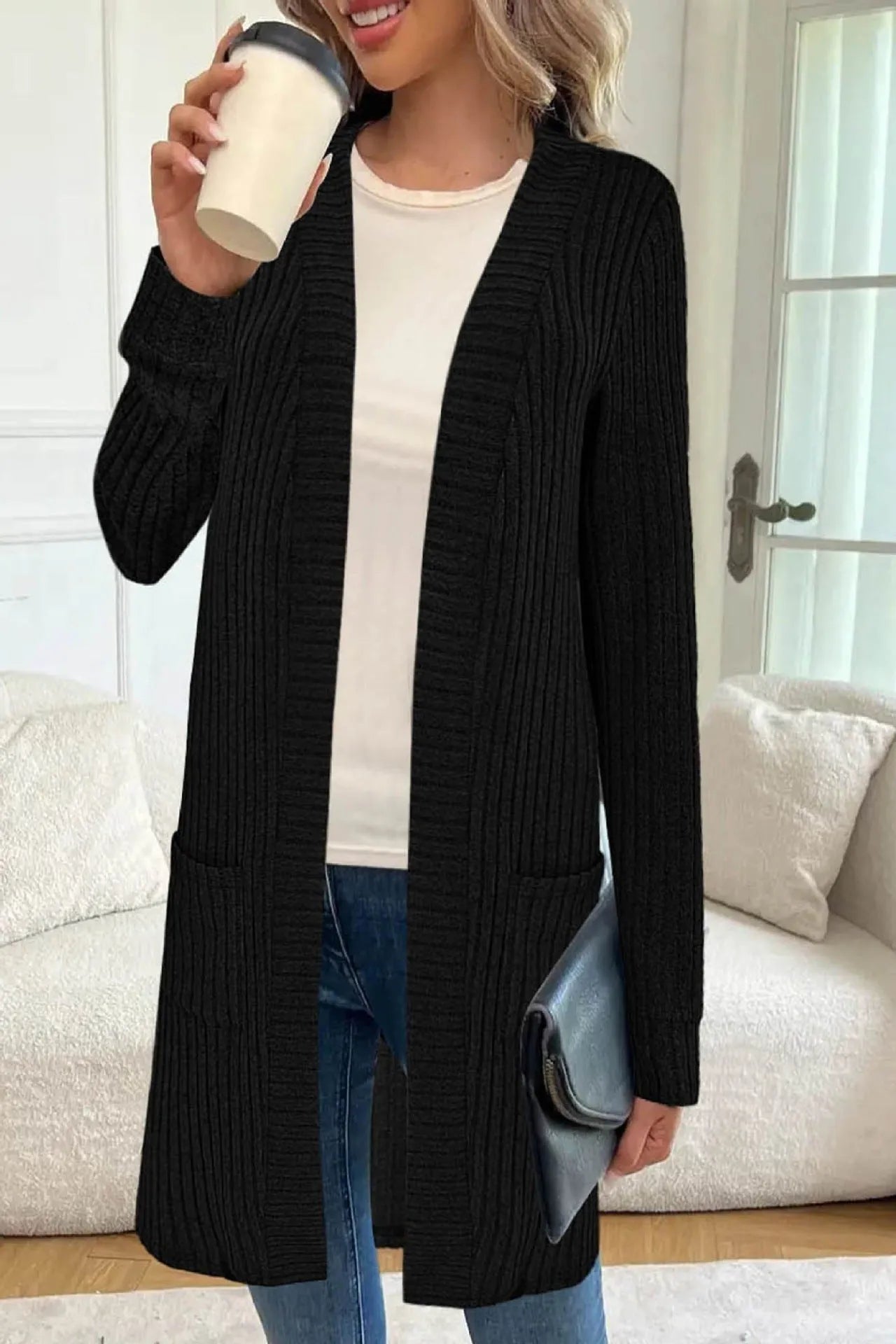 A woman wearing a loose-fit long sleeve knitted cardigan jacket with pockets, available in black, grey, or wine red.