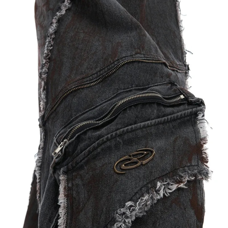 Black denim coat and trouser set with distressed raw edges and a splash-dye gradient pattern.