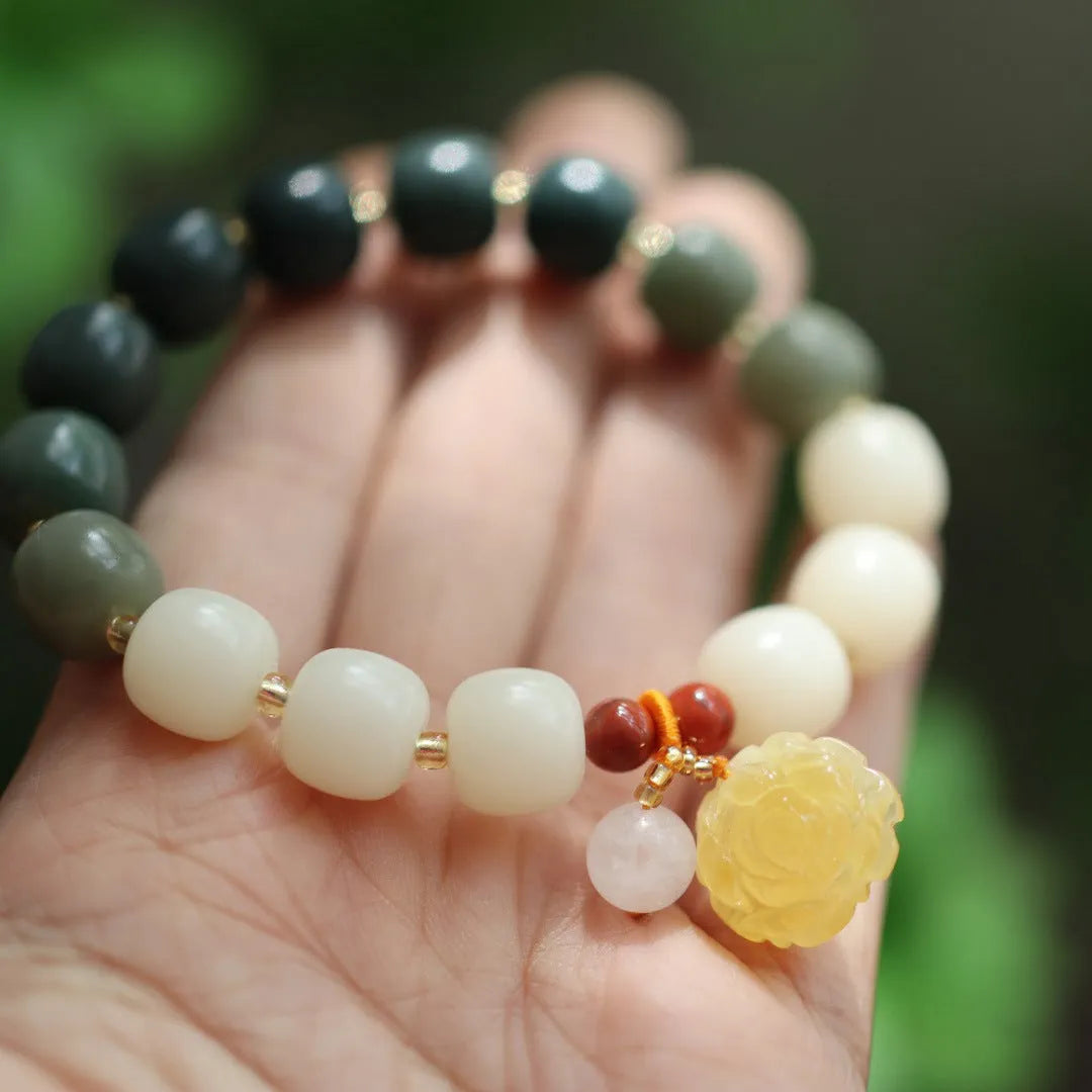 Close-up of a 10mm floral bracelet made from woven Bodhi root with gradient white jade and a natural beeswax lotus bead.