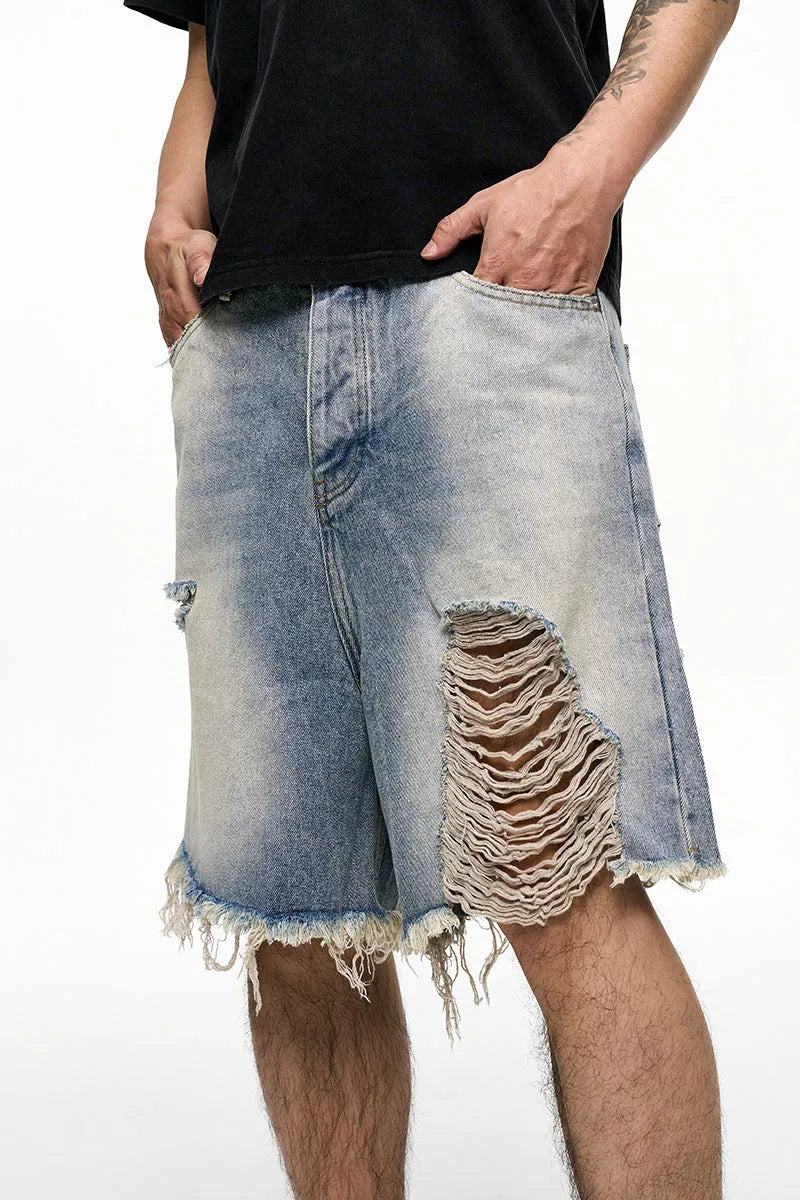 Men's light blue baggy denim shorts on a neutral background, showing wide leg and mid waist.