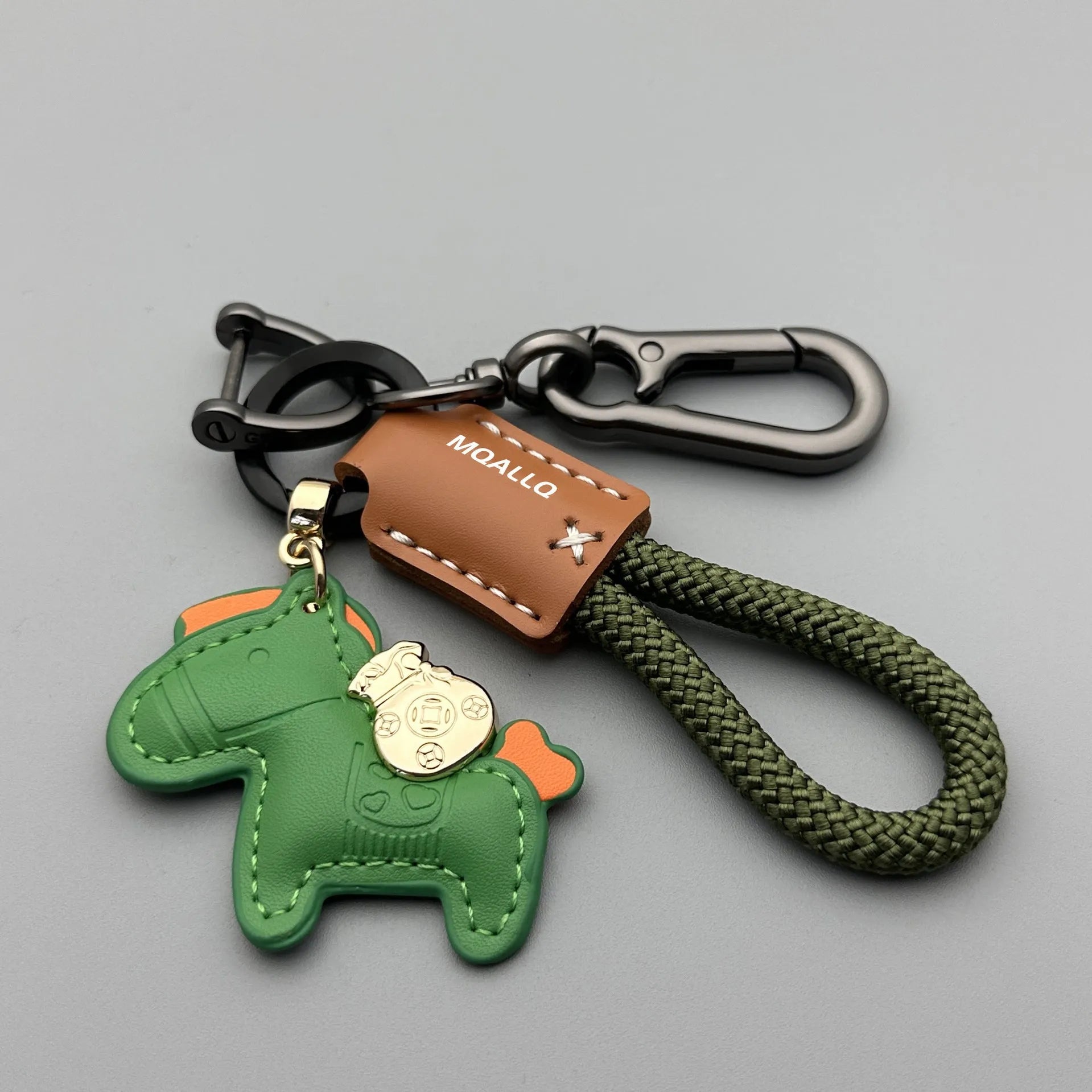 Handmade brown cowhide key ring pendant with a zinc alloy pony buckle on a green flanelle rope.
