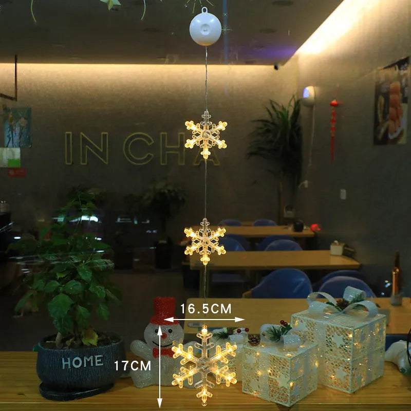 Three Christmas LED light ornaments with suction cups hanging on window