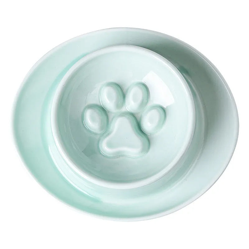 Green ceramic slow feeder pet bowl with central anti-choking basin on a white background.