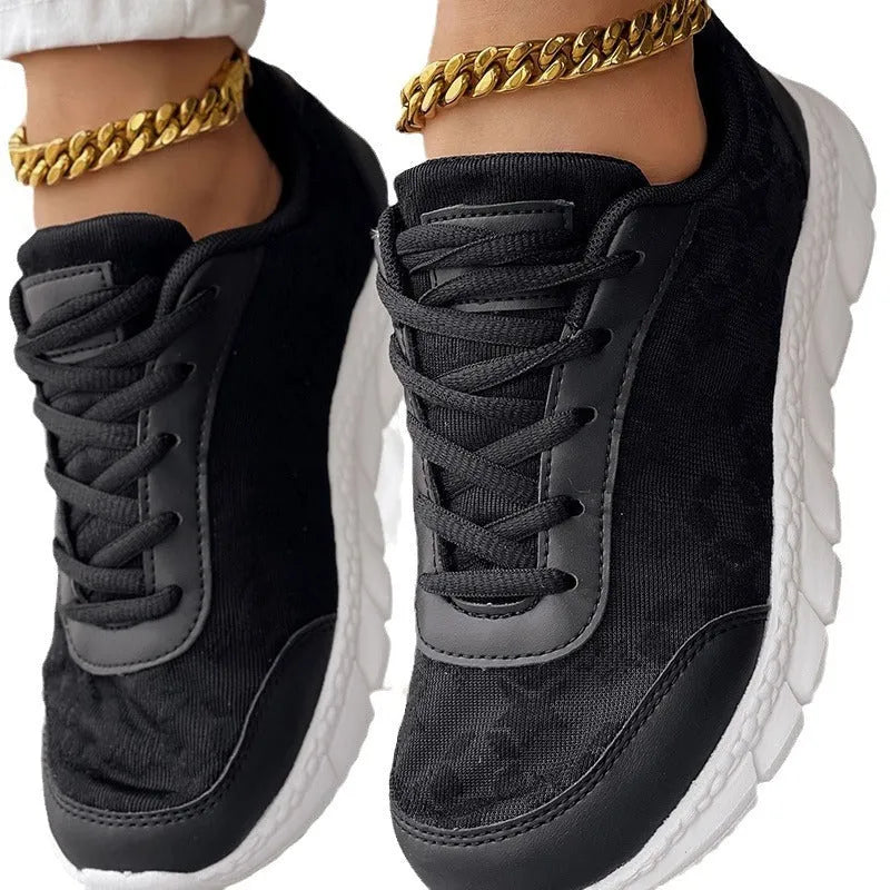 Women's white canvas running shoes with flat heel and round toe on a plain background.