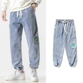 Men's loose-fit tapered cotton trousers in black, blue, and grey colours showing mid-waist design