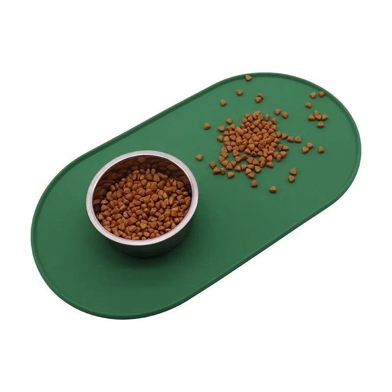 Green silicone waterproof placemat for cat food and water bowls on a floor.