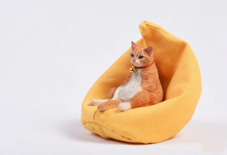 Resin lazy cat car ornament with fabric sofa, approximately 7.5cm high.