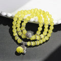 Women's opal bracelet with a Cat Eye charm, shown in one of six colours, wound three times around a wrist.