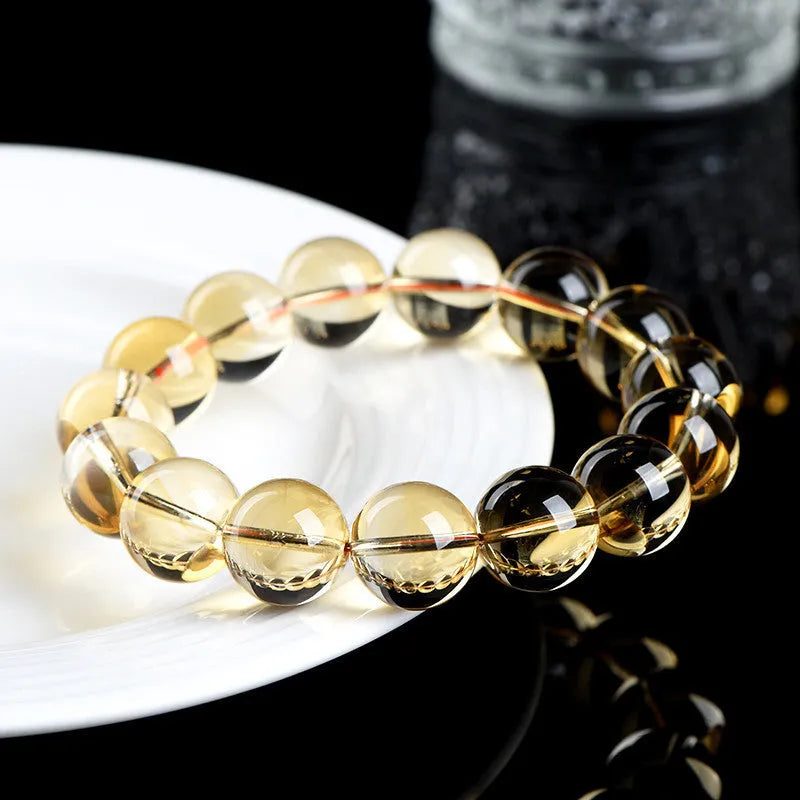 Handmade natural citrine scattered beads ball bracelet on a wrist, showing polished yellow gemstones.
