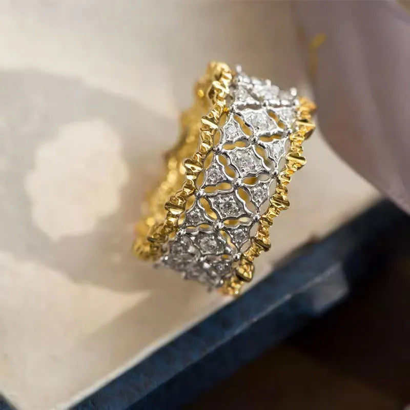 Gold two-tone geometric women's zircon ring on a plain background, showing its round stone and copper construction.