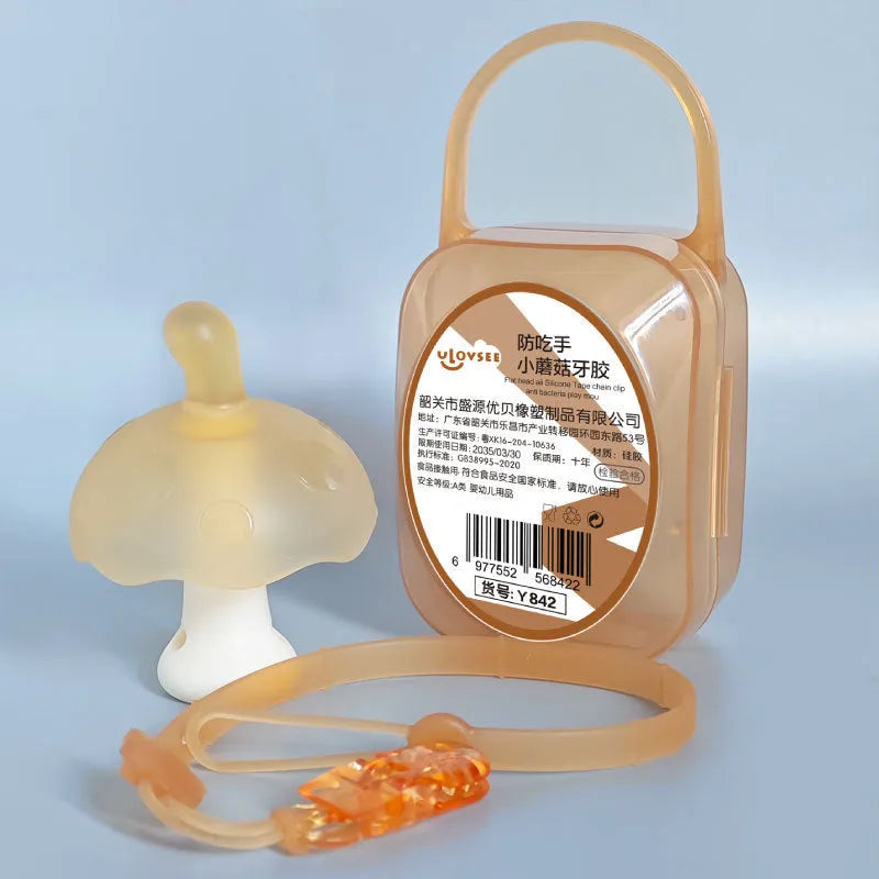 Small pink mushroom-shaped silicone chew on a transparent chain next to a clear storage box.