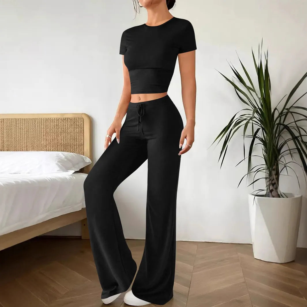 Black high-waist trousers and matching short-sleeve t-shirt set on a hanger.