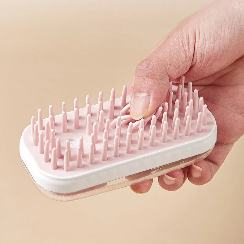 Grey and pink silicone pet bath brush for dogs and cats, handheld with soft bristles.