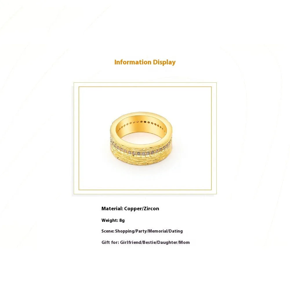 Geometric gold-colour copper ring with zircon stone on a grey background.