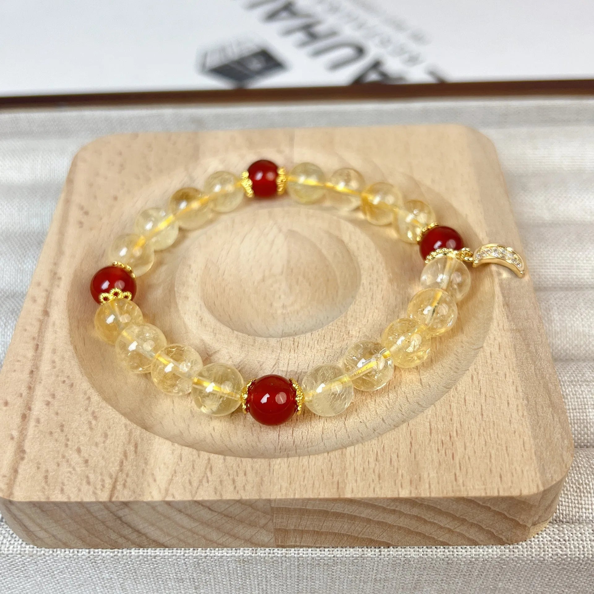 Citrine and red agate crystal moon boom bracelet for women on a white background.