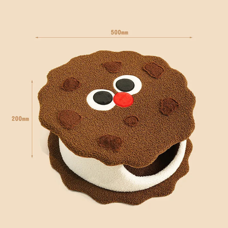 Khaki coloured enclosed cat nest shaped like a sandwich cookie with a circular entry hole.