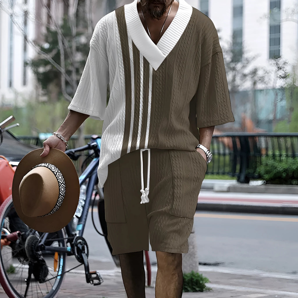Man wearing a light blue printed drop-shoulder knitted top with matching shorts from a casual summer suit.