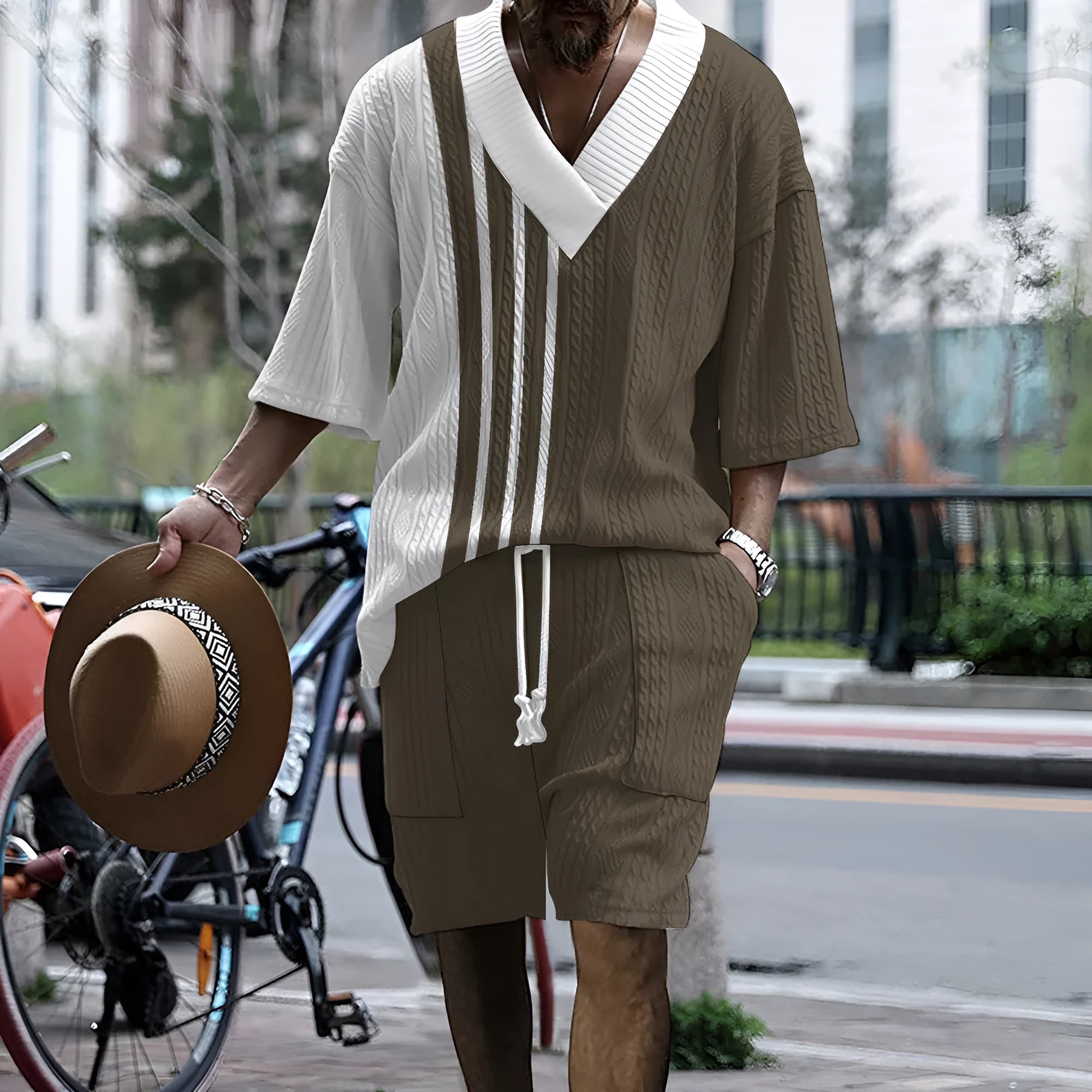 Man wearing a light blue printed drop-shoulder knitted top with matching shorts from a casual summer suit.