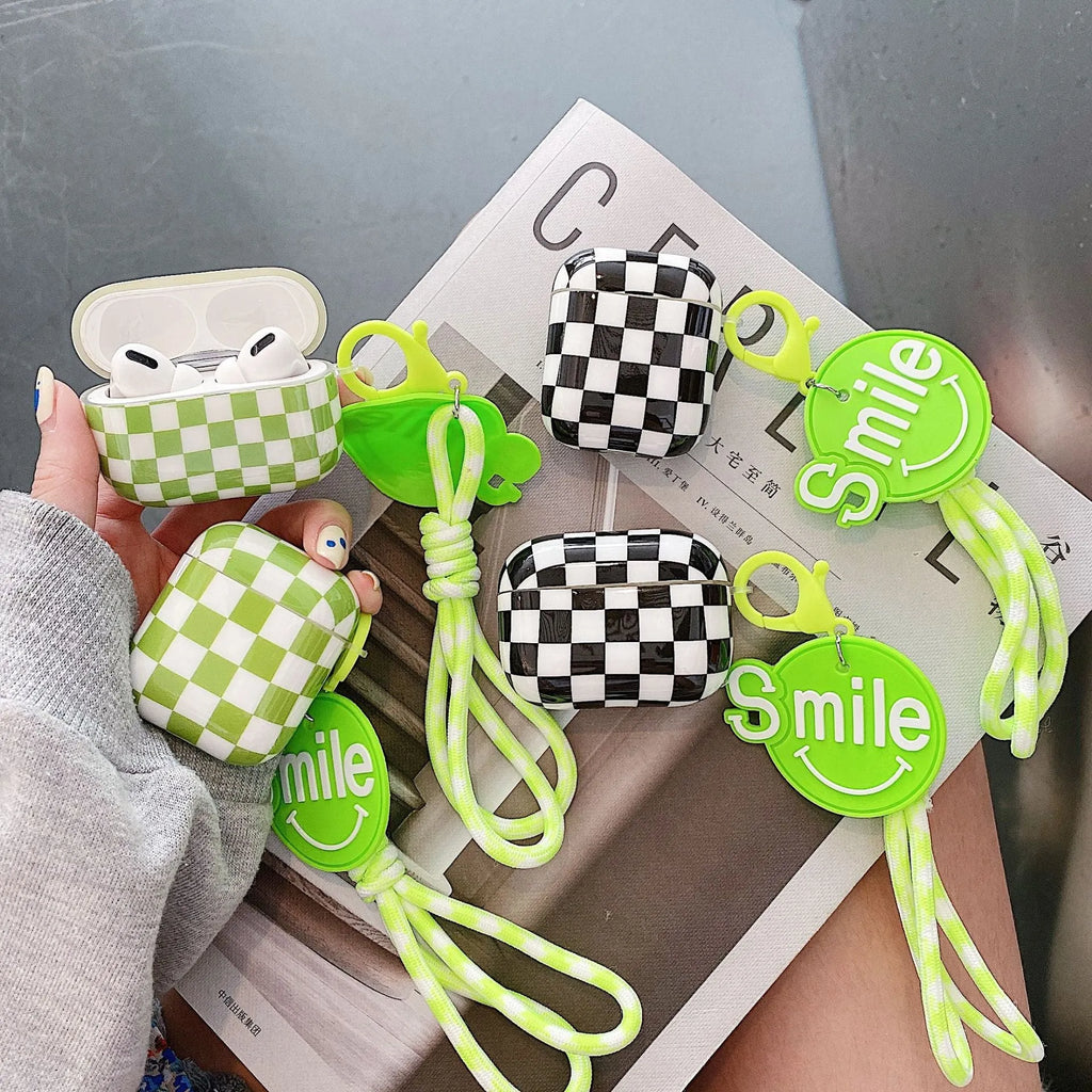 Black and green checkerboard pattern TPU protective case for Apple AirPods, shown with an optional attached lanyard.