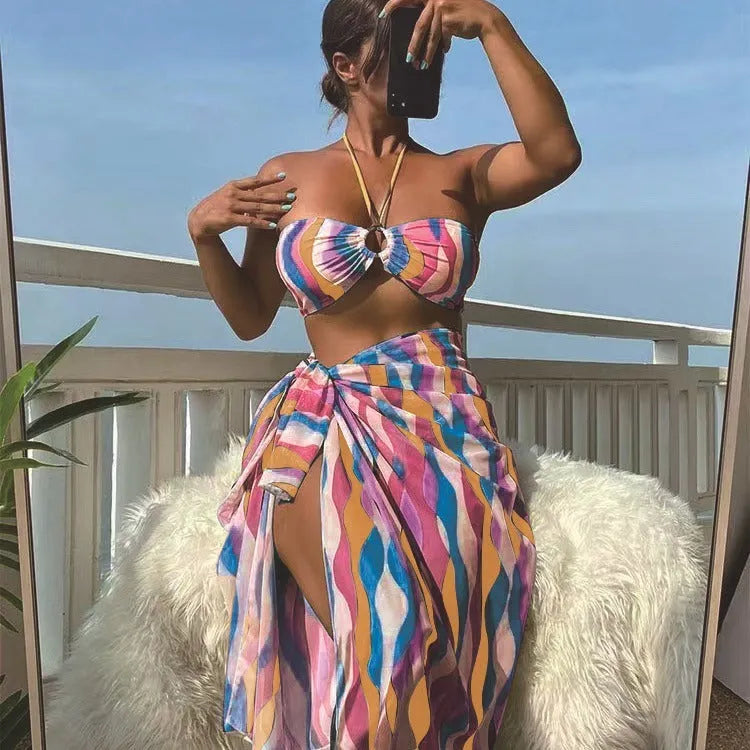 Women's yellow green printed three-piece bikini set with matching beach skirt laid flat.