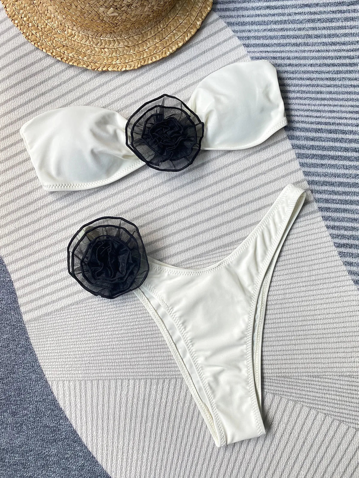 Black and white striped bikini swimsuit with cross-back tube top and floral split shorts on a mannequin.