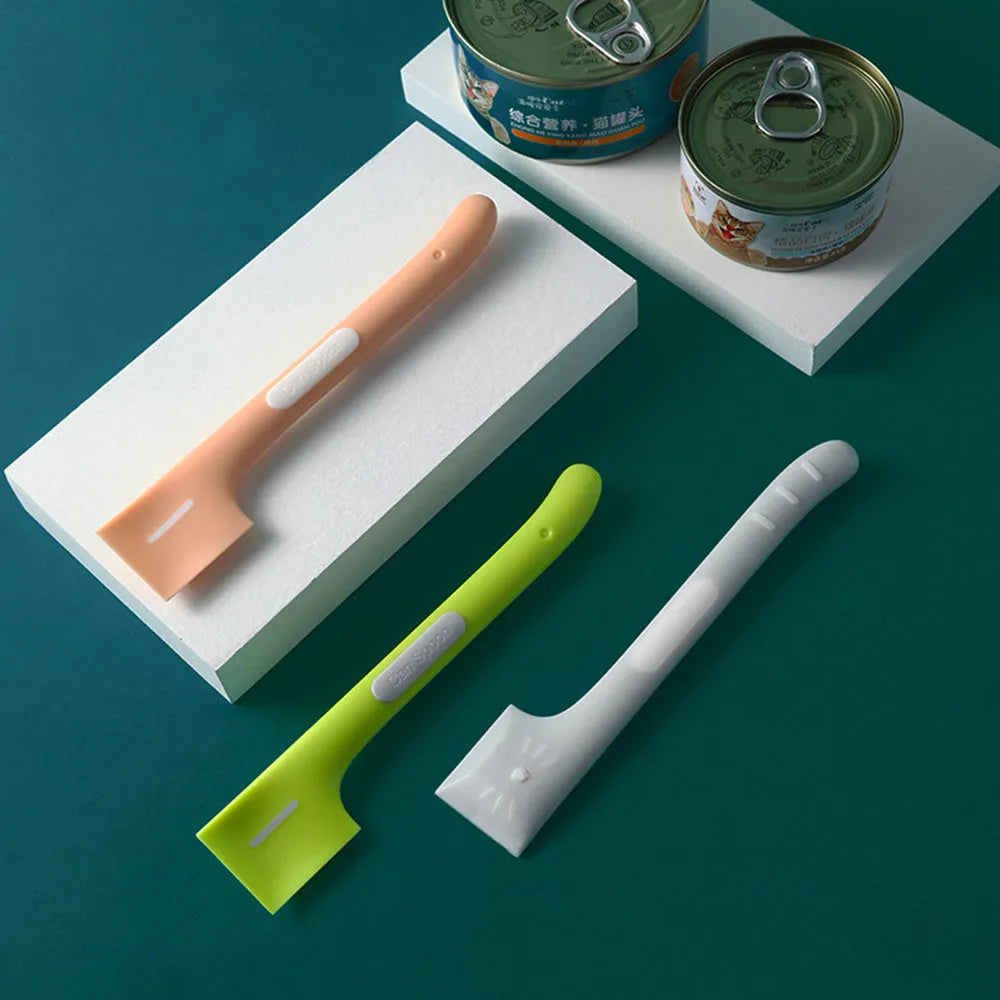 Green pet feeding spoon with long handle and right-angle edge for scraping canned dog or cat food.