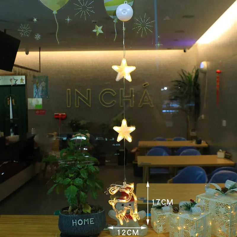 Three Christmas LED light ornaments with suction cups hanging on window