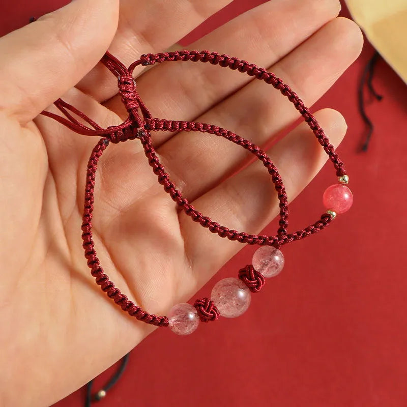 Woven red rope bracelet with alloy beads and natural strawberry quartz or obsidian stone beads
