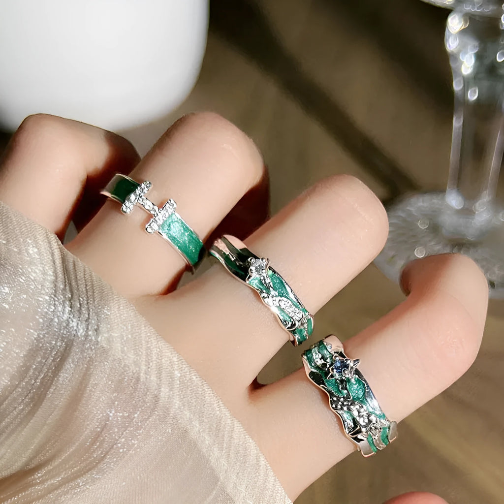 Mint green and copper asterism ring with asymmetric folding design on a hand.