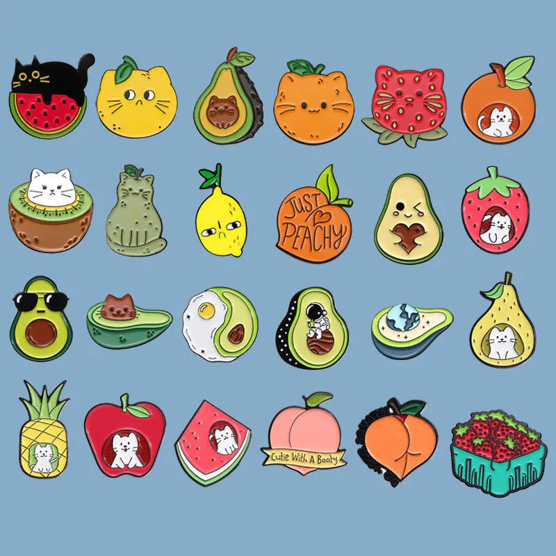 Colourful cartoon fruit and letter design on a silver-toned metal brooch pin.