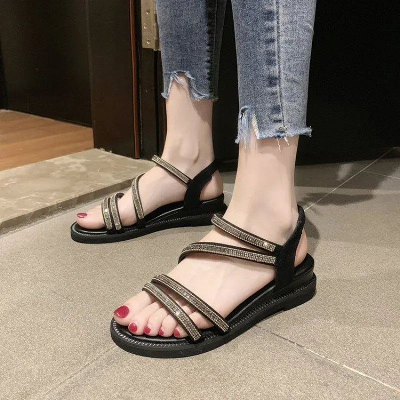 Gold and silver women's flat sandals with round toe, rhinestone details, elastic band, and rubber sole.