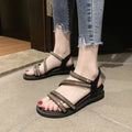 Gold and silver women's flat sandals with round toe, rhinestone details, elastic band, and rubber sole.